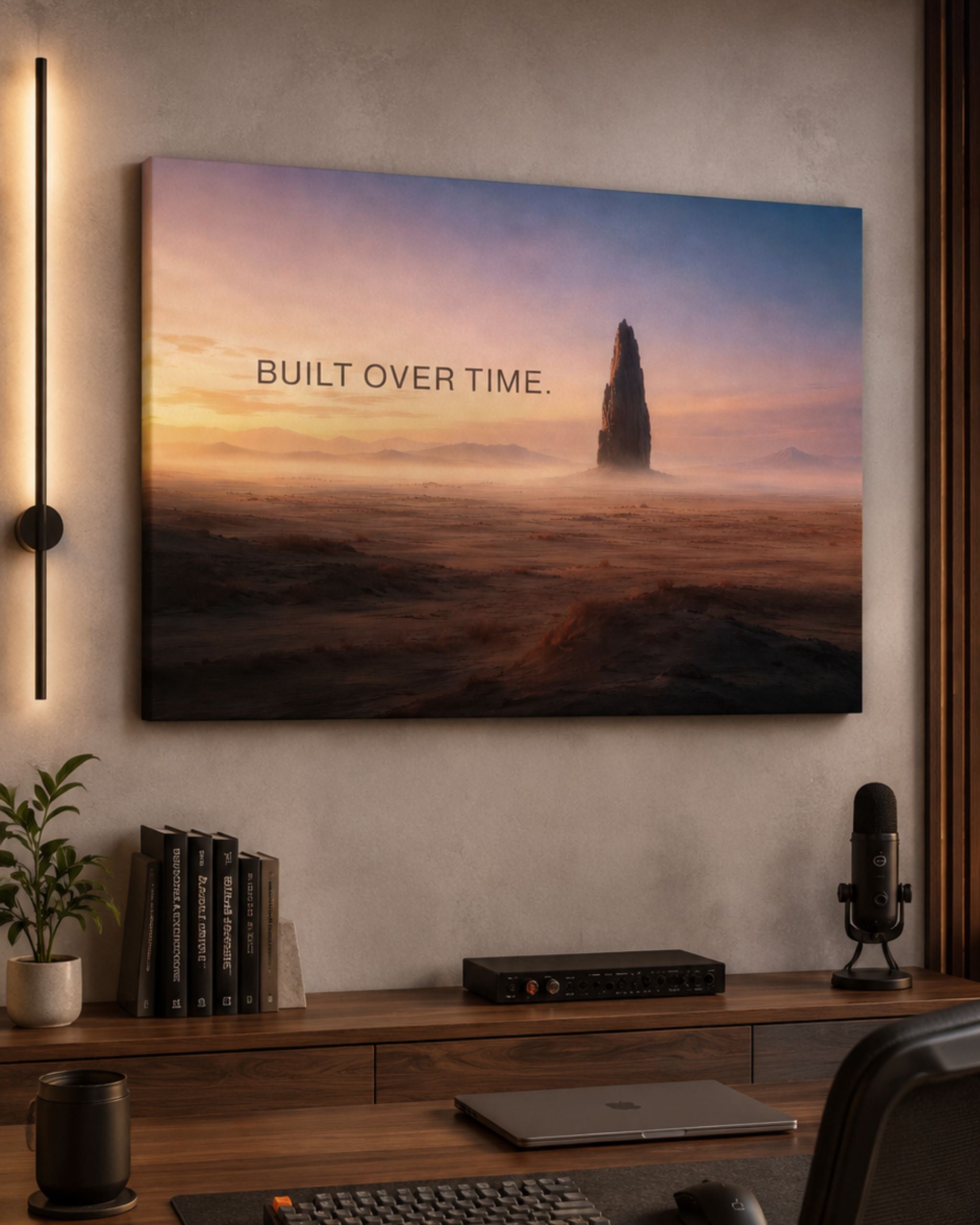Leinwandbild „BUILT OVER TIME.“ von SuccessRemind mit monumentalem Fels in weiter Wüstenlandschaft bei warmem Morgenlicht - präsentiert im Home Office.