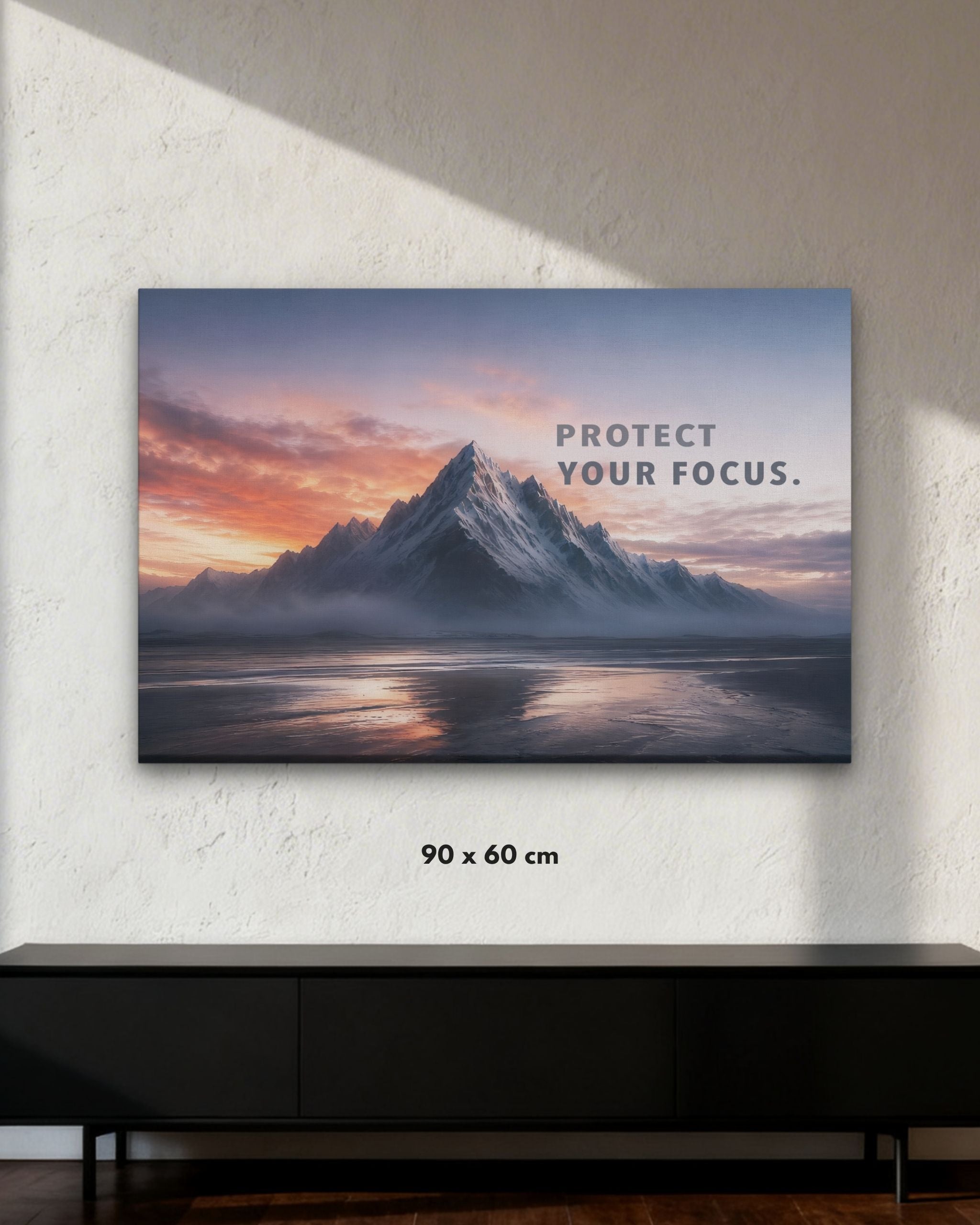 Statement-Piece „PROTECT YOUR FOCUS.“ als Leinwandbild im Raum mit Bergmotiv und klarer Fokus-Botschaft in der Größe 90x60cm