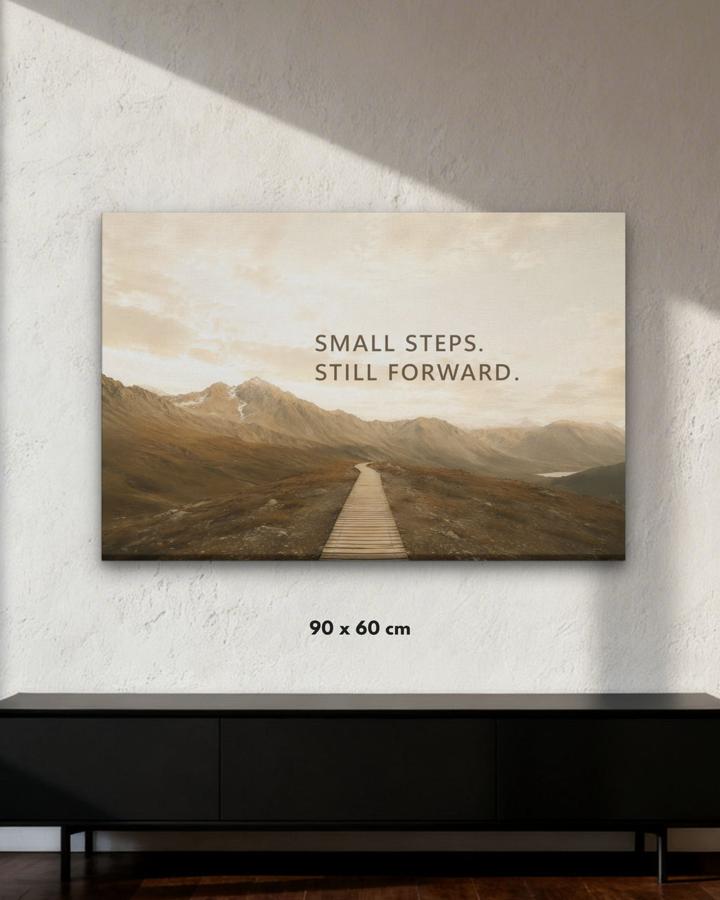 Small Steps. Still Forward. Leinwandbild mit Berglandschaft, Holzsteg und motivierendem Statement über Fortschritt in der Größe 90x60cm.