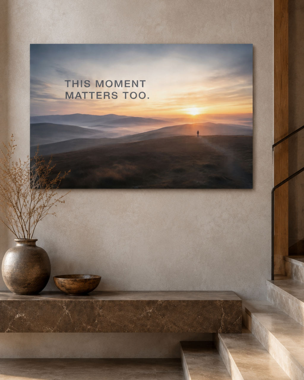 Statement-Wandbild auf Leinwand mit dem Mindset "This moment matters too." aufgehängt im Eingangsbereich.